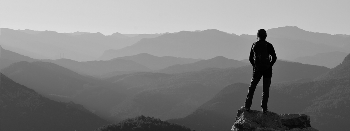 Mensch in Bergen mit Aussicht über Gebirge